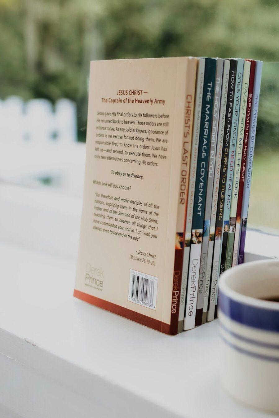 Christian devotional books and a cup of coffee on a windowsill